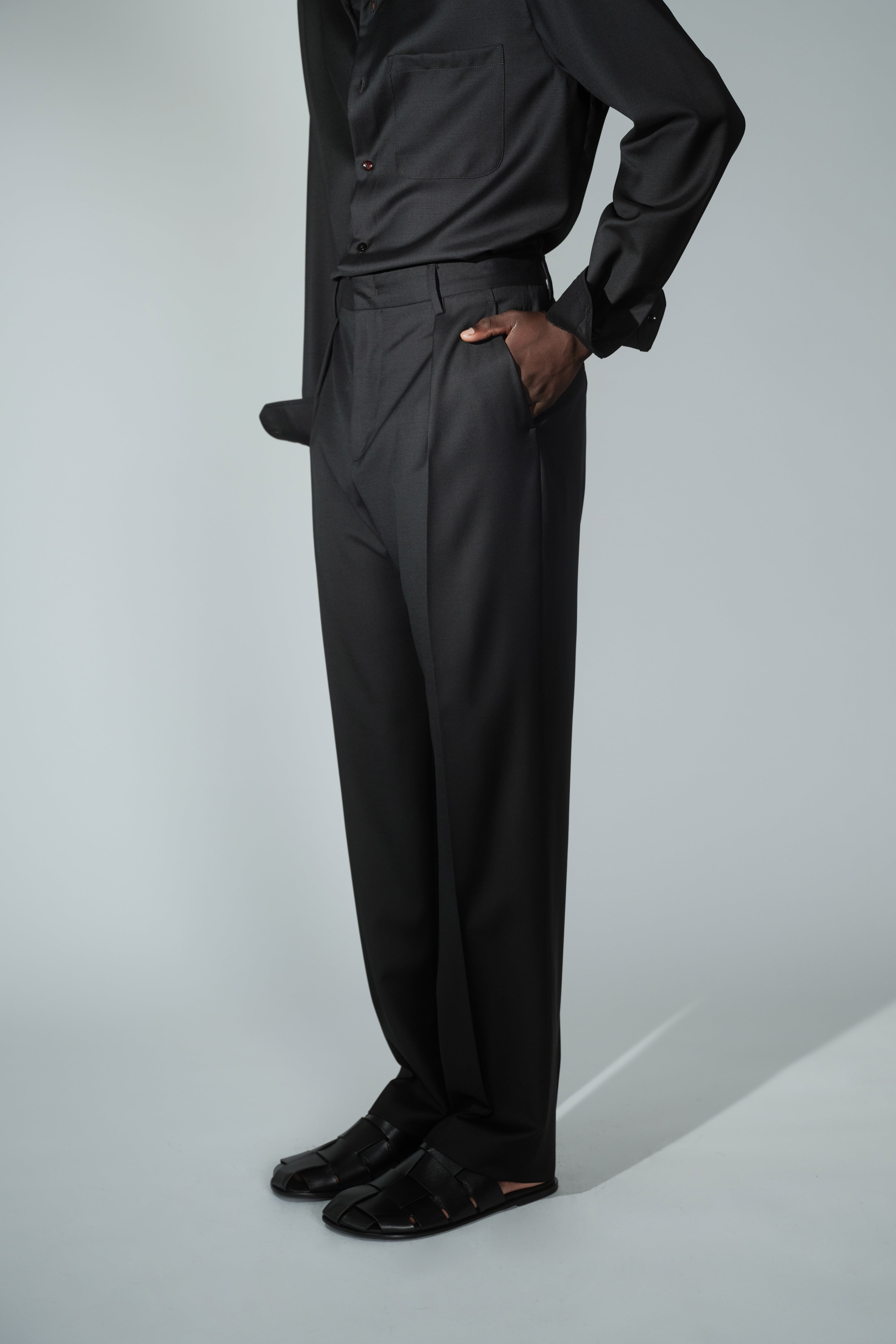 Side view of RÆR STUDIOS x Kevin Lutolf pleated trousers in black