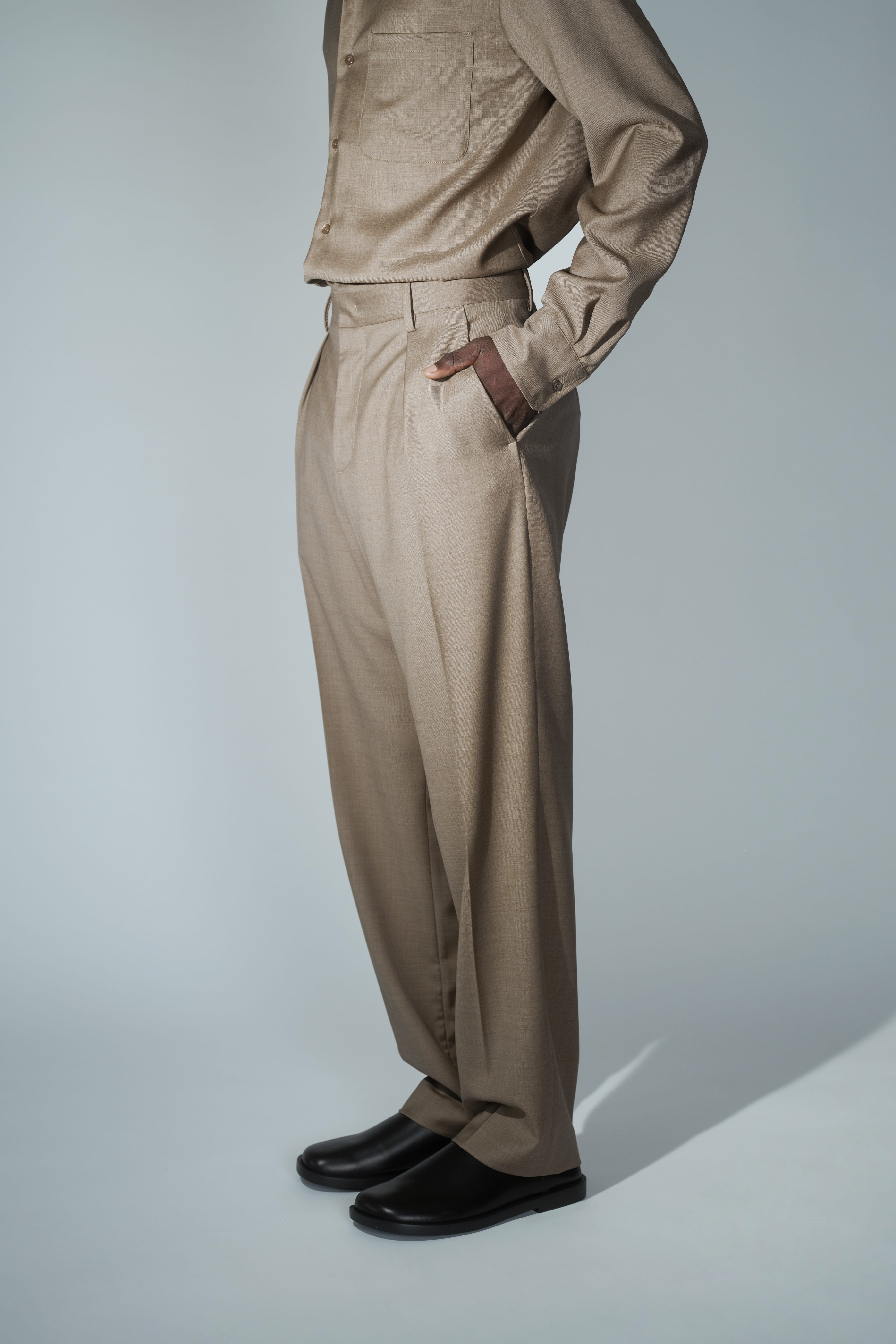 Side view of RÆR STUDIOS x Kevin Lutolf pleated trousers in olive