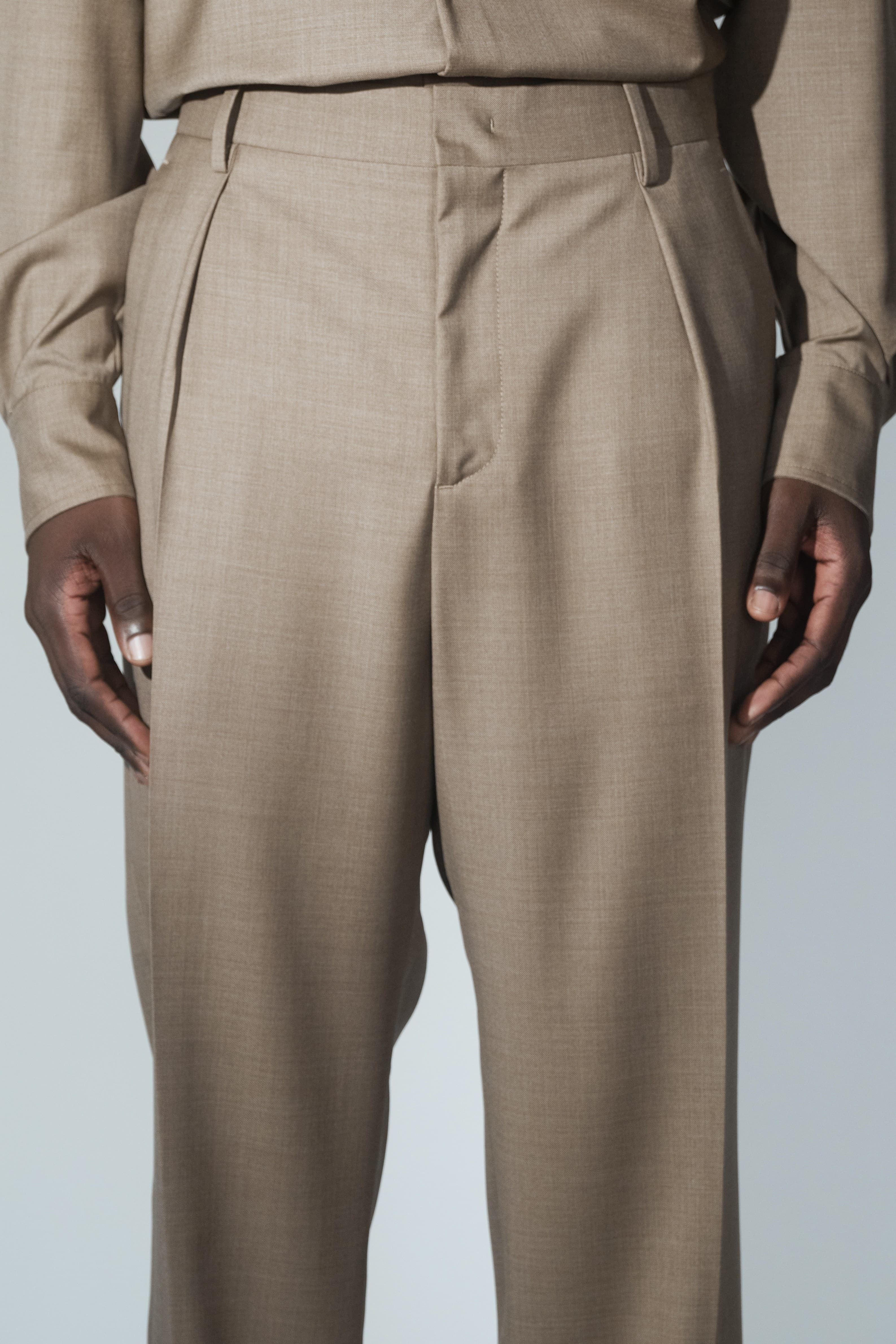 Close-up of RÆR STUDIOS x Kevin Lutolf pleated trousers in olive
