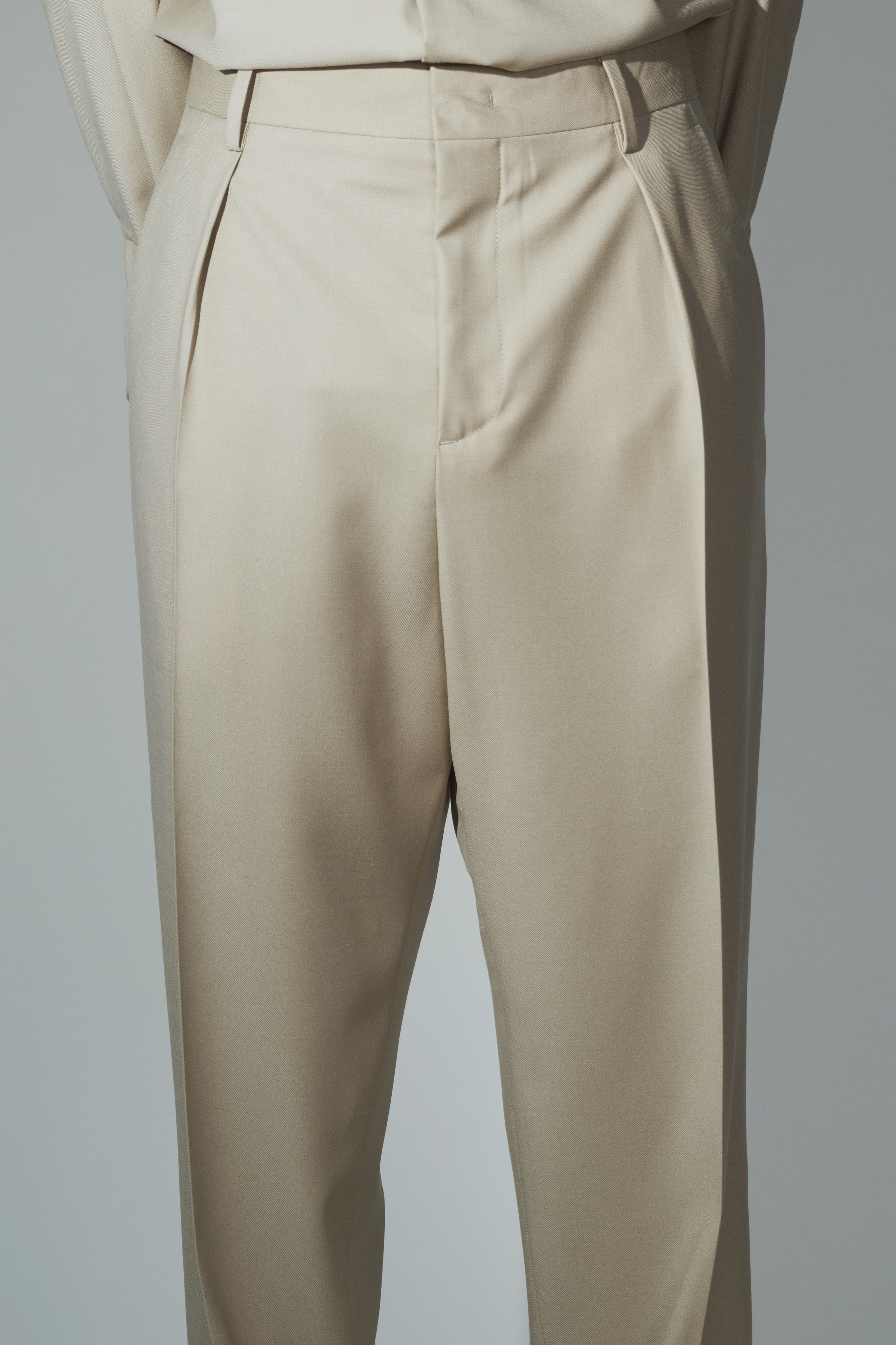 Close-up of RÆR STUDIOS x Kevin Lutolf pleated trousers in sage